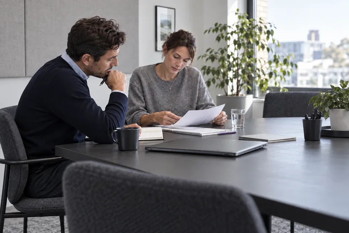 Colleagues reviewing documents around an office table
