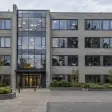 Commercial property entrance viewed across a landscaped courtyard