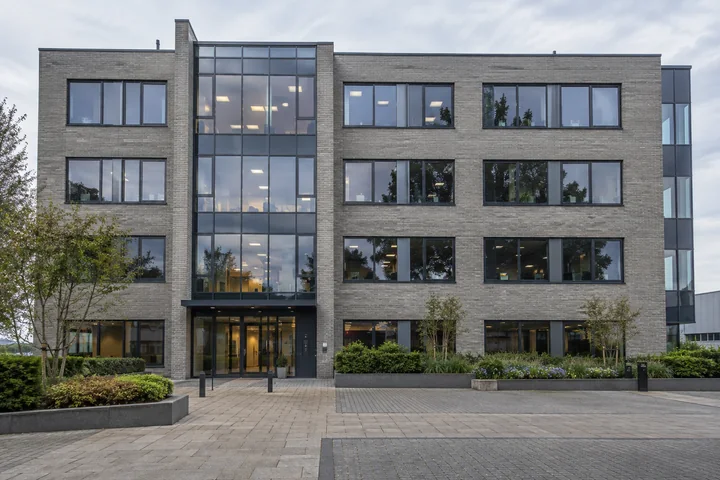 Commercial property entrance viewed across a landscaped courtyard