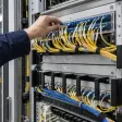 Technician checking connections in a fiber distribution rack